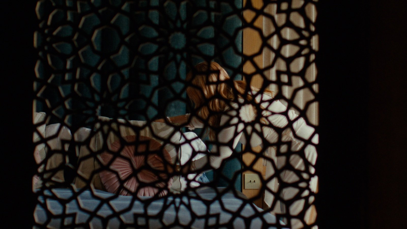 Silvia through an Andalusian lattice screen